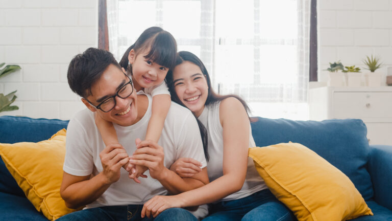 Family sitting together on the couch smiling at short happiness quotes