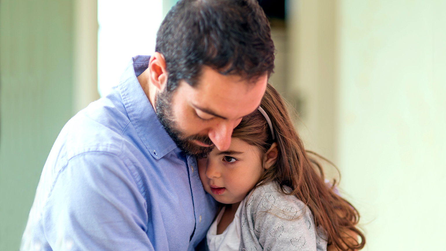 A father hugs his young daughter; FatCamera/Getty Images