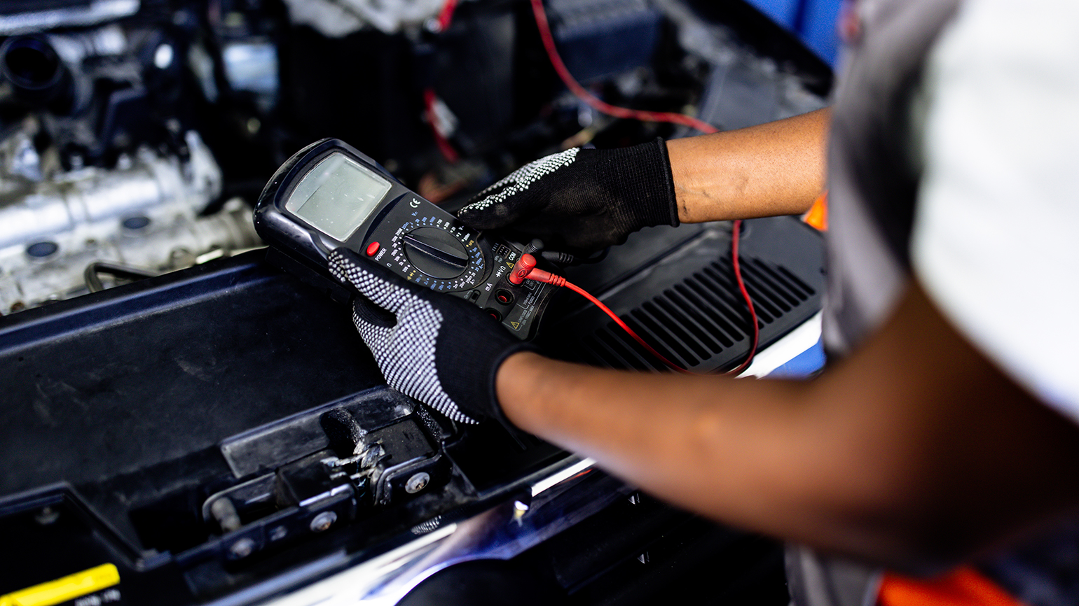 A mechanic checks a car battery/Getty Images