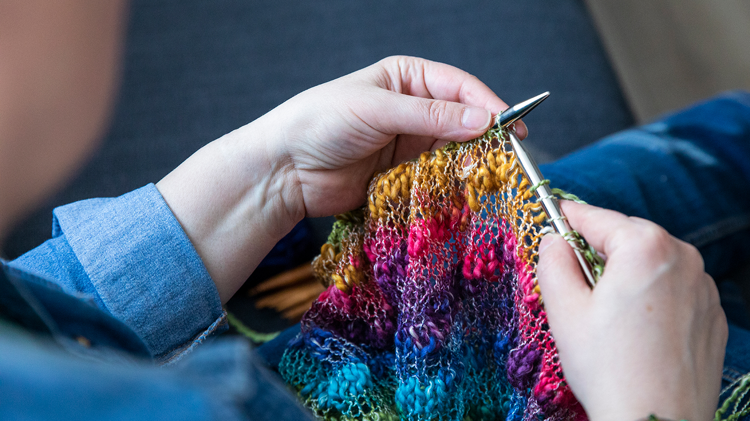 A women's hand knitting a prayer shawl; anilakkus / Getty Images