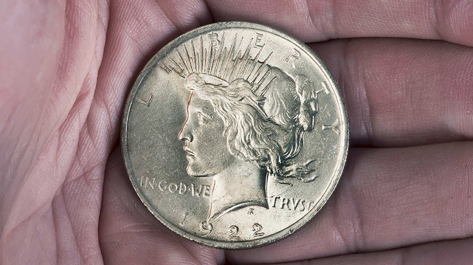 A 1922 silver dollar resting on an open hand; Getty Images
