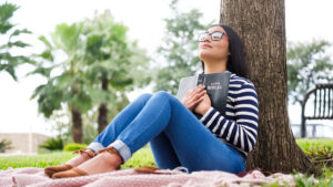 A woman clasps her Bible in the great outdoors.