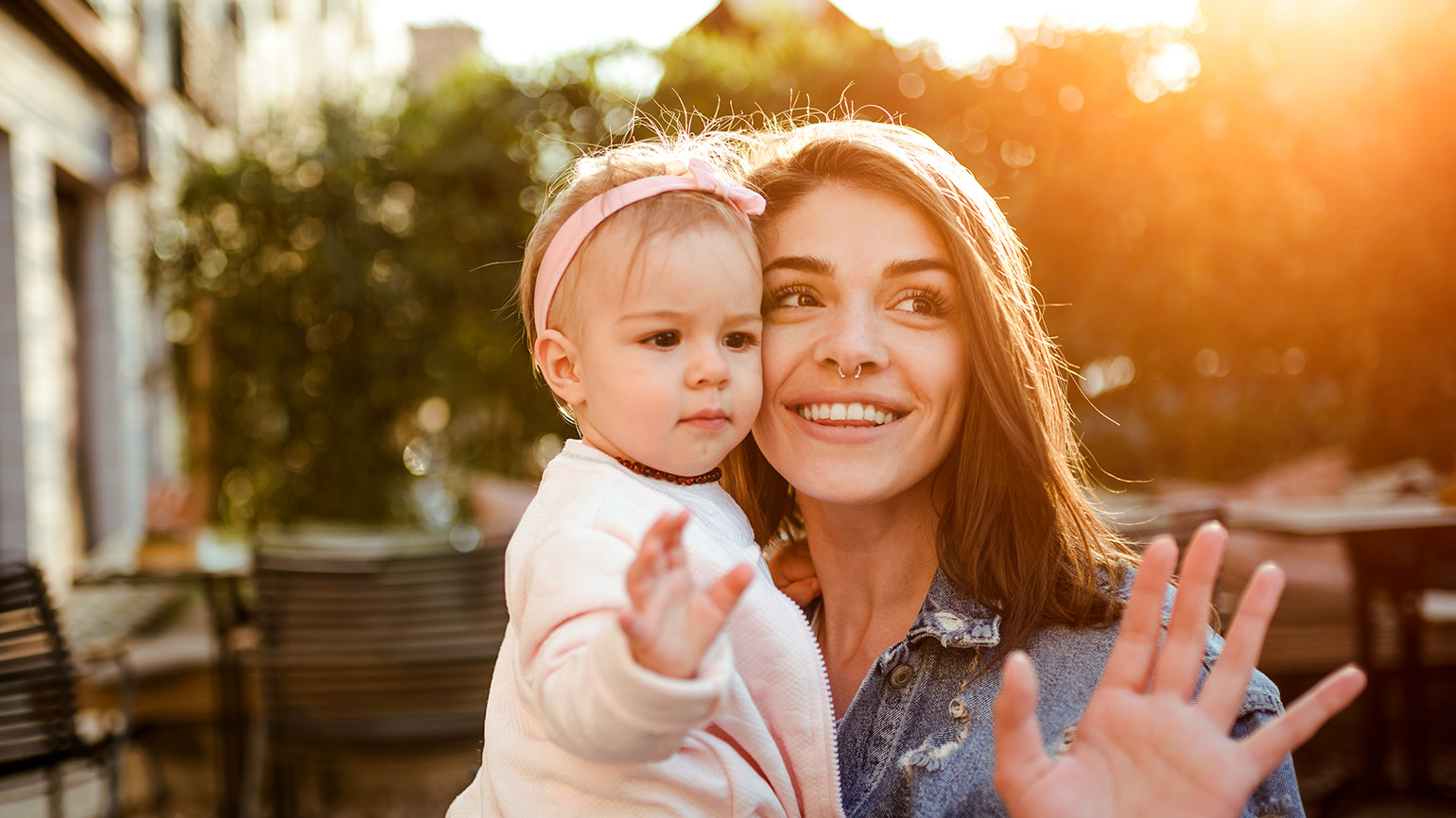 Young mom and baby daughter waving