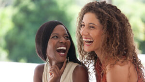 Two woman laughing together; iStock / Getty Images Plus