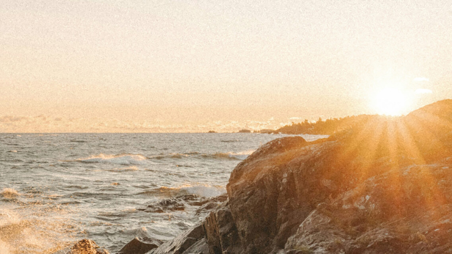 A rocky beach at sunset; Unsplash