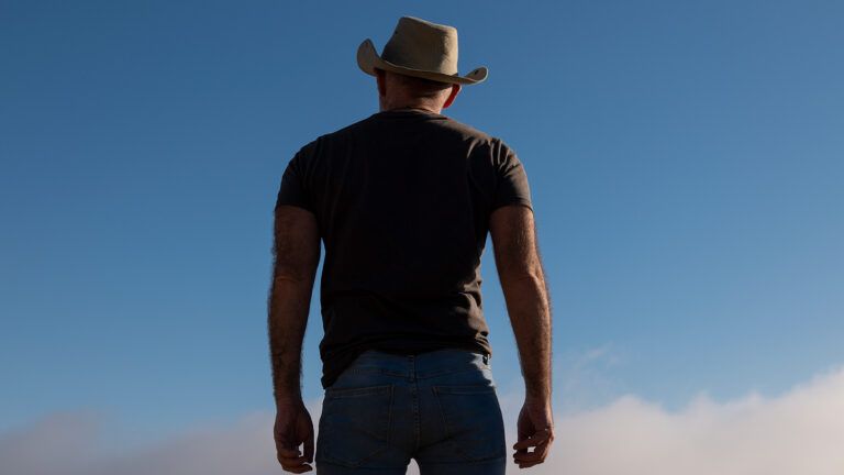 A man in a cowboy hat, seen from behind; Getty Images