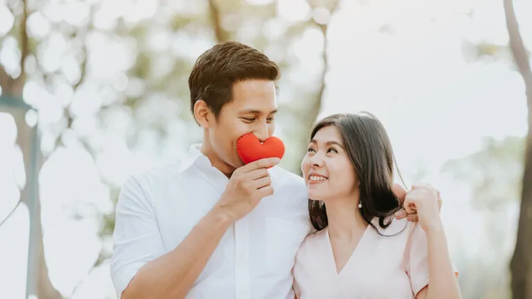 Young couple outside with a Valentine's day devotional red heart