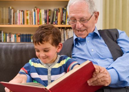 Elderly man reading to child
