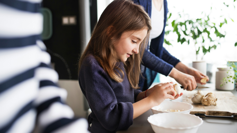 Young girl cooking with family in the kitchen.