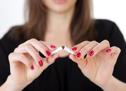 A smoker inspired to kick the habit breaks a cigarette in half.
