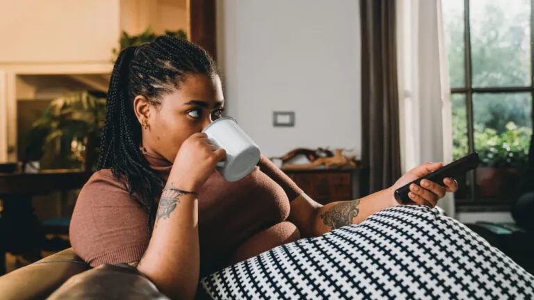 Woman sitting on the couch giving up binge watching tv for Lent