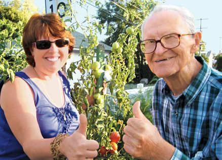 Sharon Craig with her father, Bill Holub, in his tomato garden