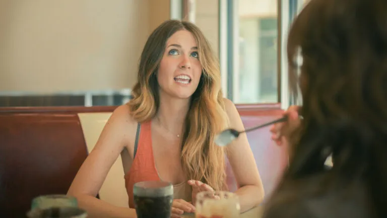 woman sitting in a cafe with her friend talking about giving up sarcasm for lent