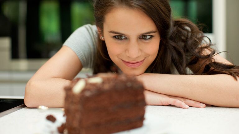 woman staring at chocolate cake trying to give up sweets for lent