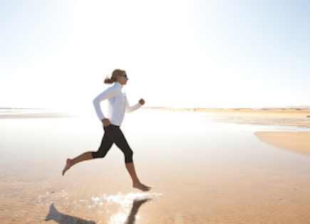 carefree woman enjoying a run on the beach