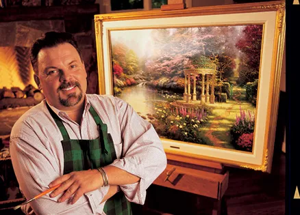 Thomas Kinkade with one of his paintings