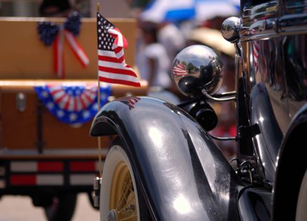 Flag-festooned antique cars in a Memorial Day parade