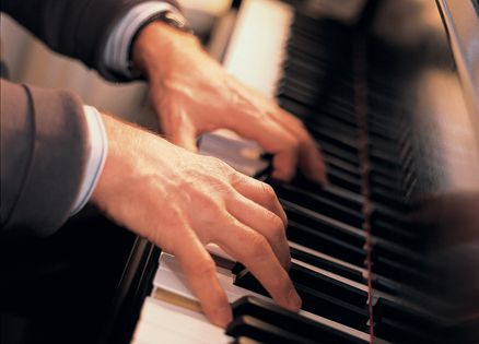 Close-up of a man's hands playing piano