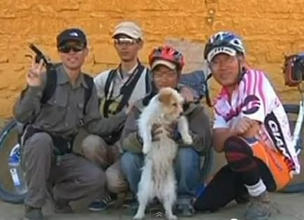 Stray dog with its new owners, a group of cyclists.