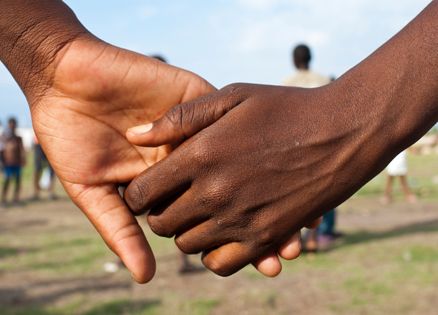 Close-up of clasped hands of young Haitian children