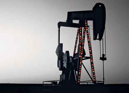 Picture of oil well festooned with colorful Christmas lights
