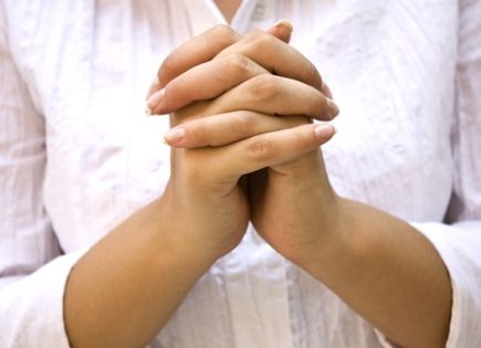 woman's hands clasped in prayer.