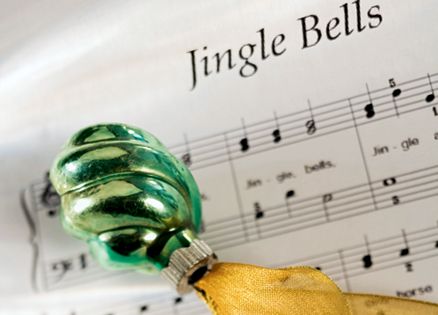 Jingle Bells sheet music and a green Christmas ornament with gold ribbon