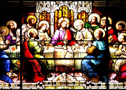 An illuminated stained-glass window showing the Last Supper