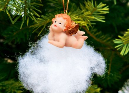 A Christmas ornament depicting an angel on a cloud