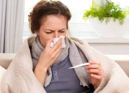 sick woman taking her temperature