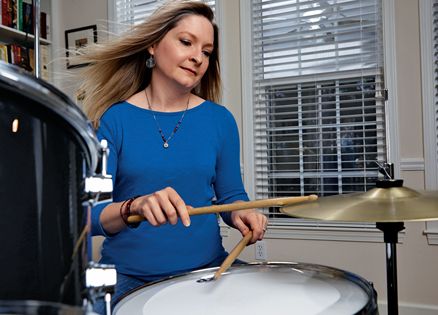 Ginger Rue, sticks in hand, at her drum set