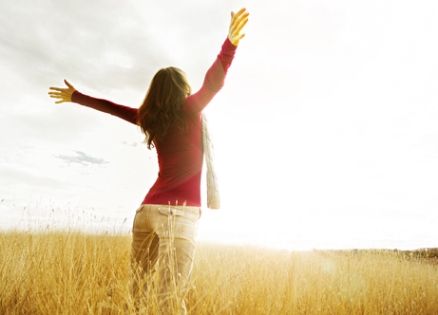 woman praising God as the sun rises