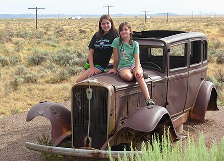 Marci's daughters Sarah and Emma perch upon an vintage car along Route 66
