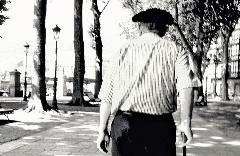 An older gentleman in a black beret strolls away
