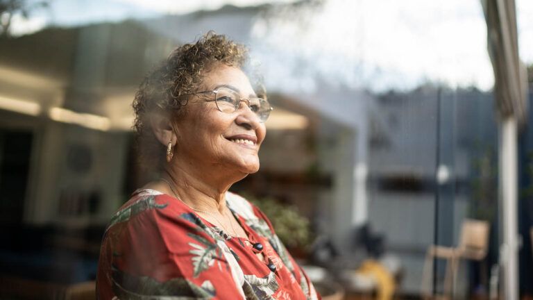Senior woman looking out the window feeling gratitude after reading devotions