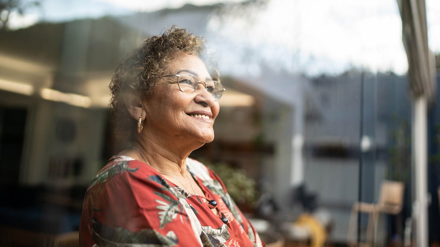 Senior woman looking out the window feeling gratitude after reading devotions