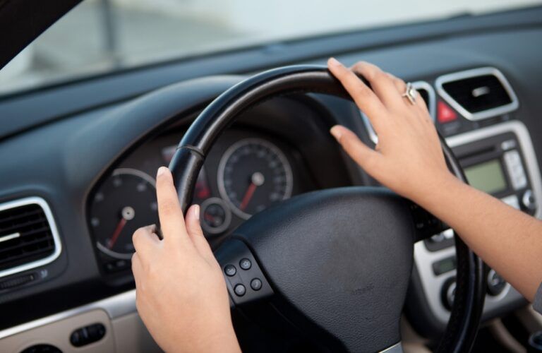 woman with hands on steering wheel
