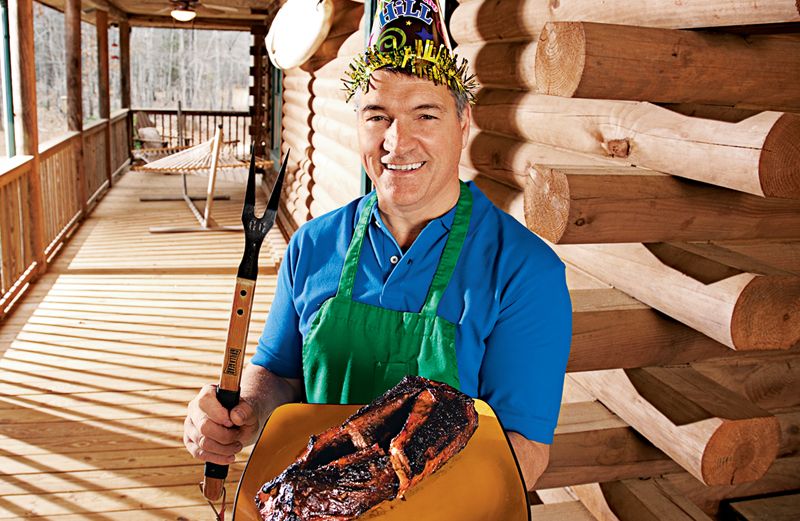 Rick Garmon in a festive party hat displaying his smoked pork tenderloin