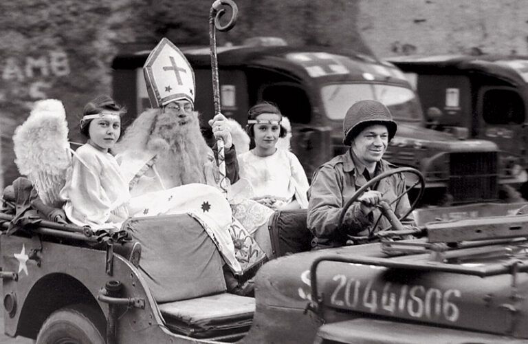 Richard Brookins as St. Nicholas arrives in a jeep accompanied by two angels