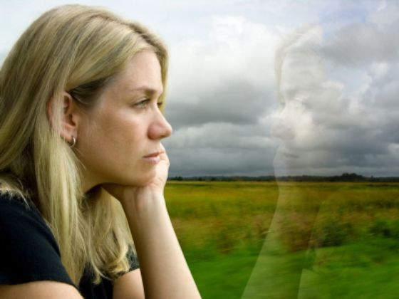 Fearful woman looking out window