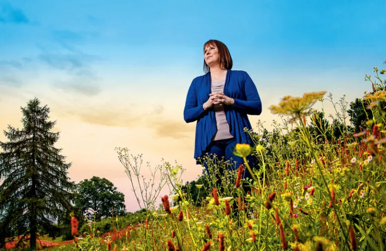 Susan Call standing in a field of flowers