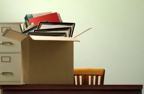 a packed-up office with box of belongings.