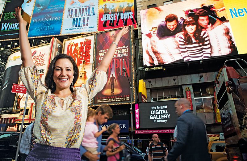 Renee Heitmann with arms aloft in Times Square