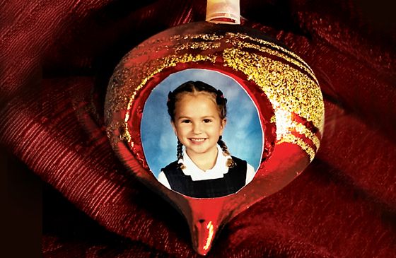 A red Christmas ornament with gold glitter and Micaela's kindergarten picture
