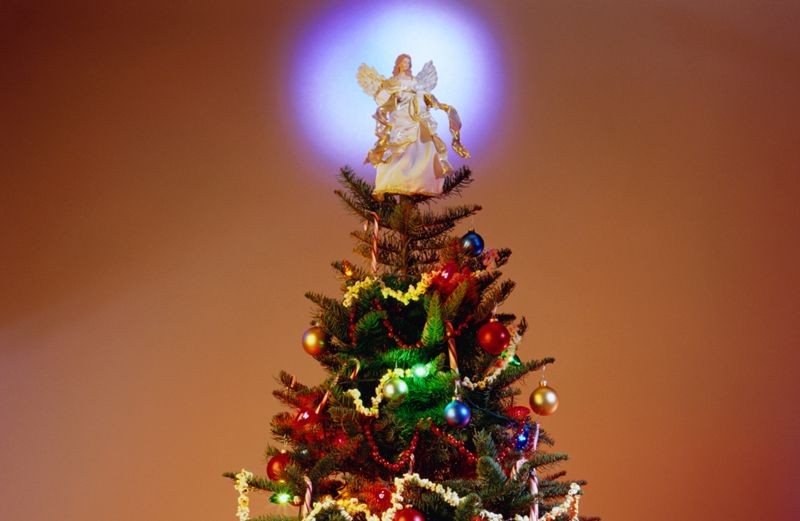 A Christmas tree with a glowing angelic topper