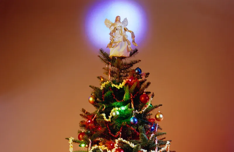 A Christmas tree with a glowing angelic topper