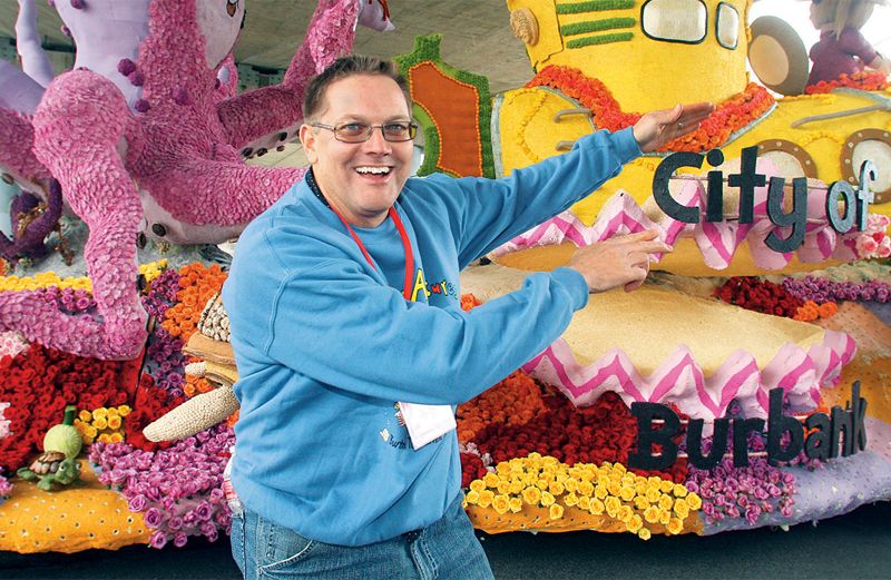 Richard Burrows poses in front of the parade float he designed.