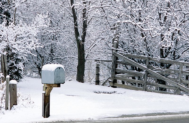 A roadside mailbox on a snowy, icy day