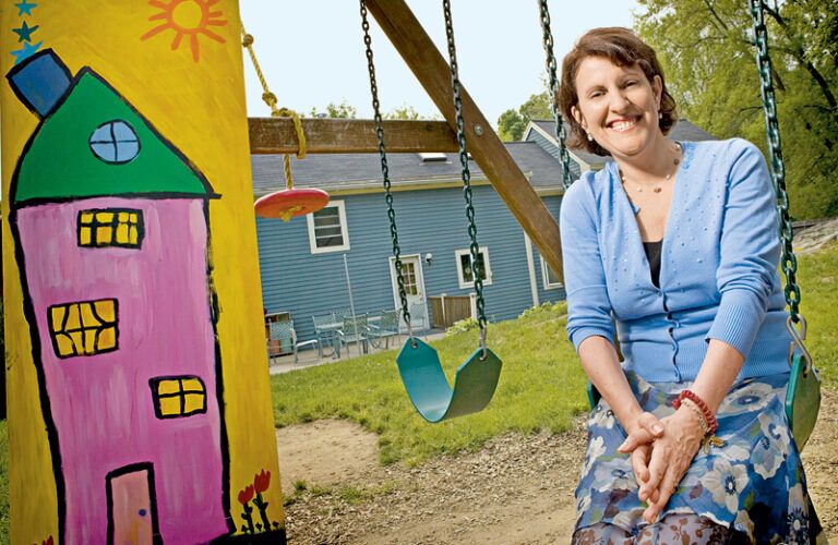 Linda Carden sits in a playground swing outside the Star House.