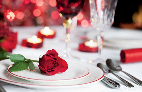 A single red rose on a lovely dinner table